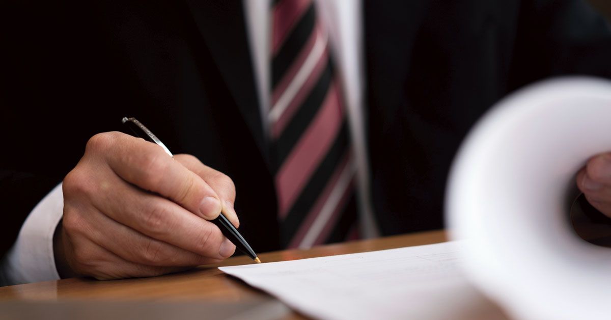 Man in suit signing papers