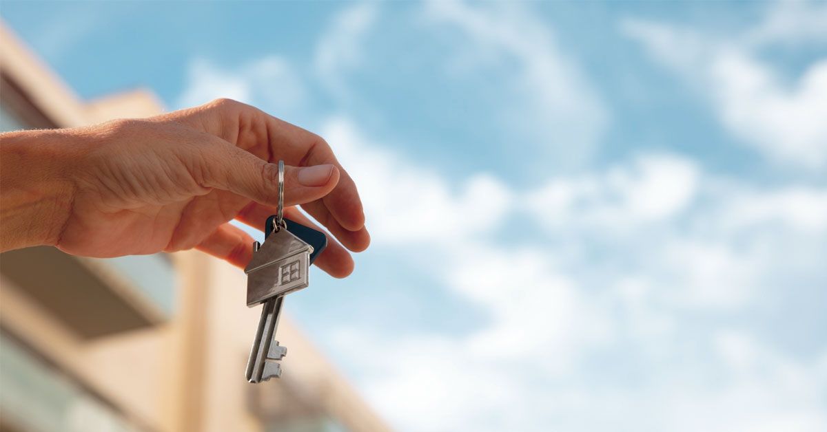 Person holding keys of his property in the air